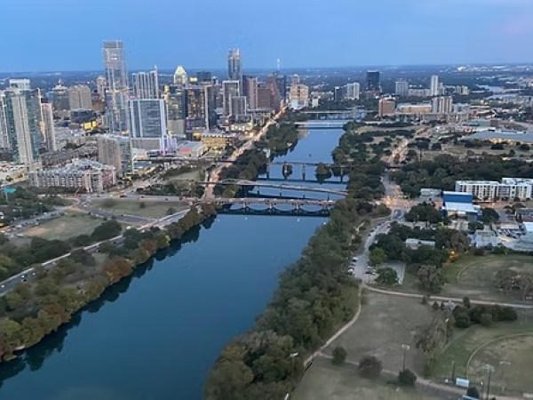 Aerial view of a city skyline and river with bridges at dusk.